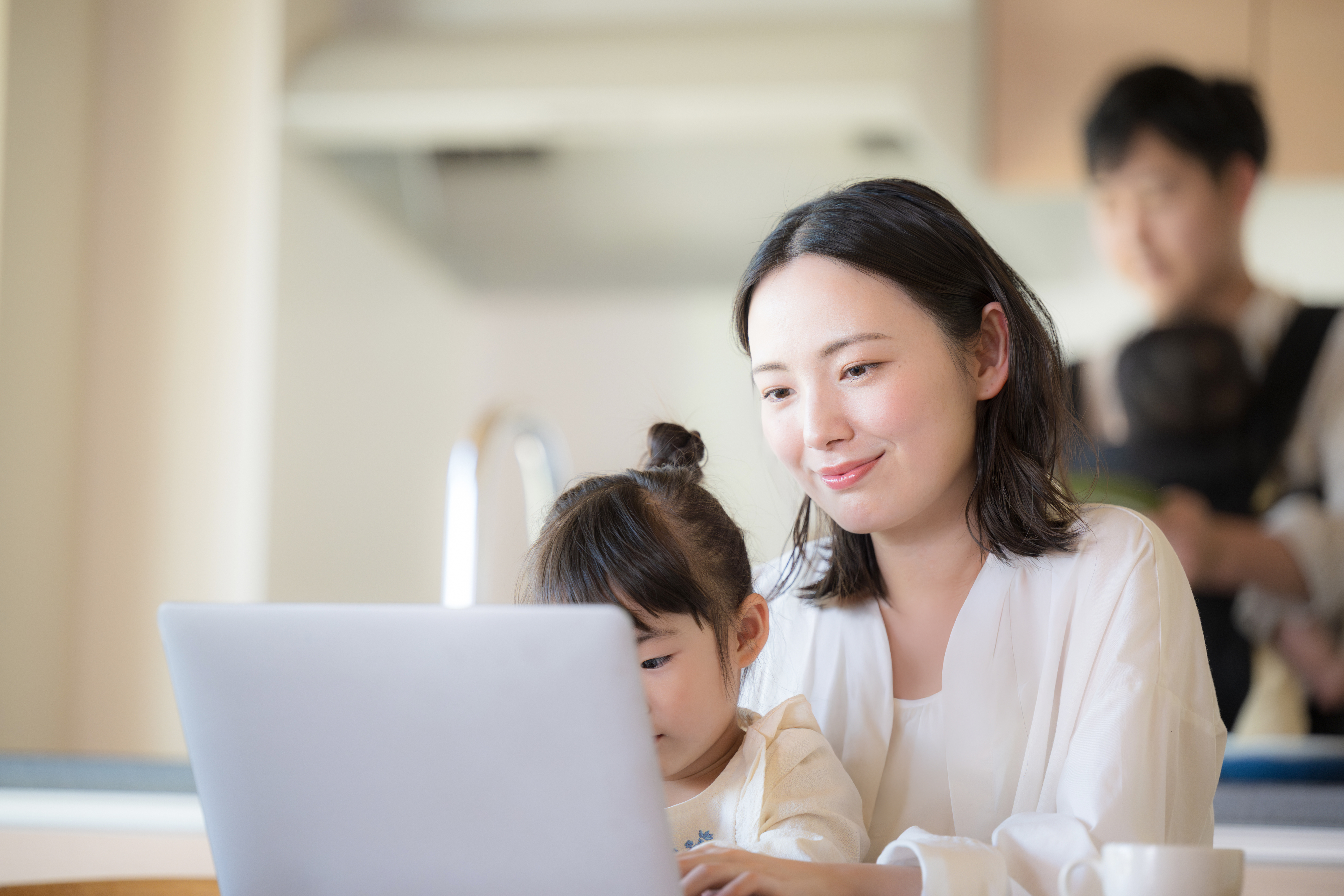 子どもと一緒にパソコンに向かう女性